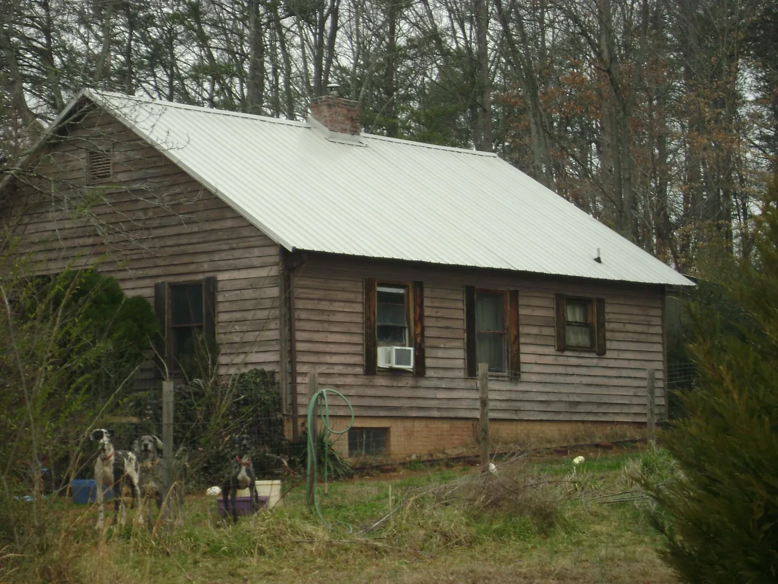 White metal roof on an old wood sided farmhouse, from a Metal Roof Installation job in Frostproof